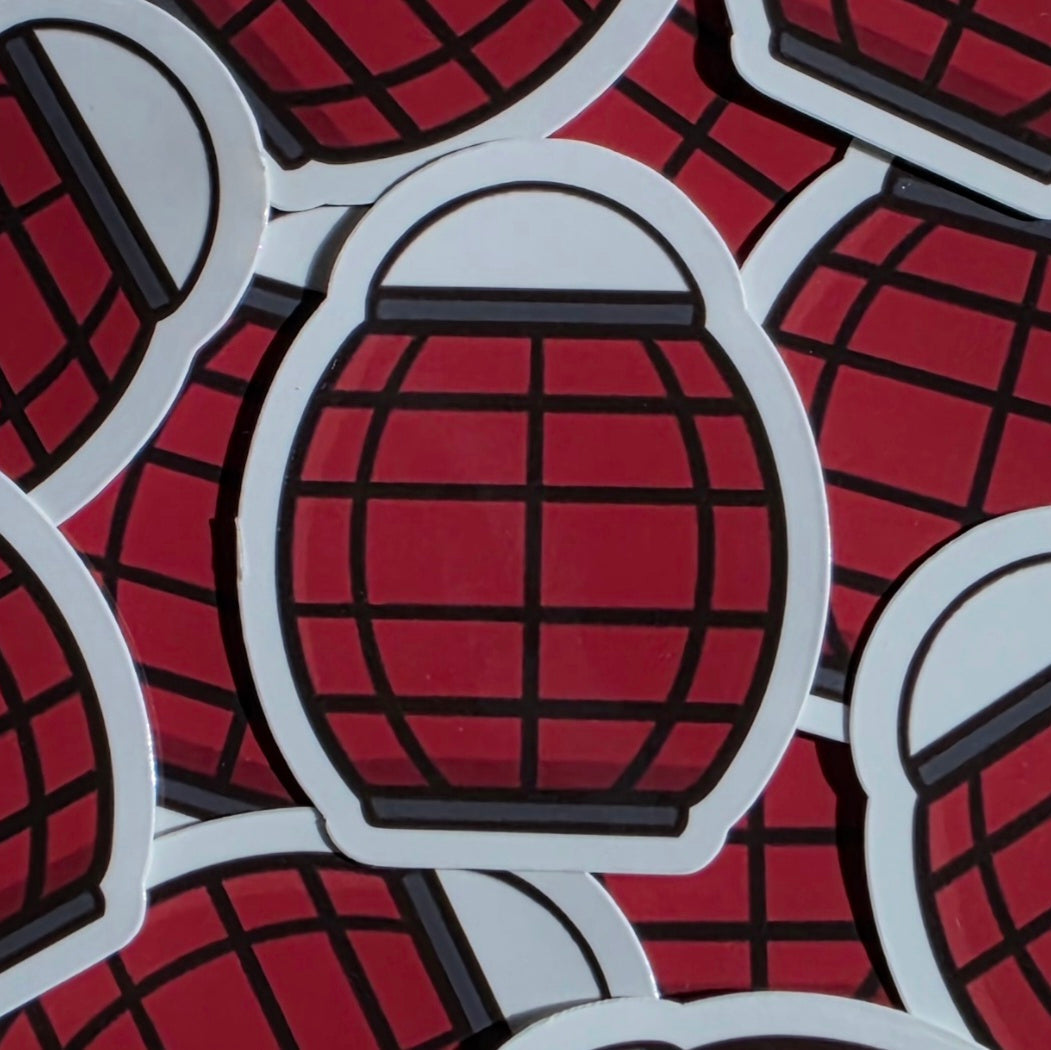 A close-up of multiple die-cut stickers featuring a red paper lantern design with black grid lines and a white border, overlapping on a matching red background.