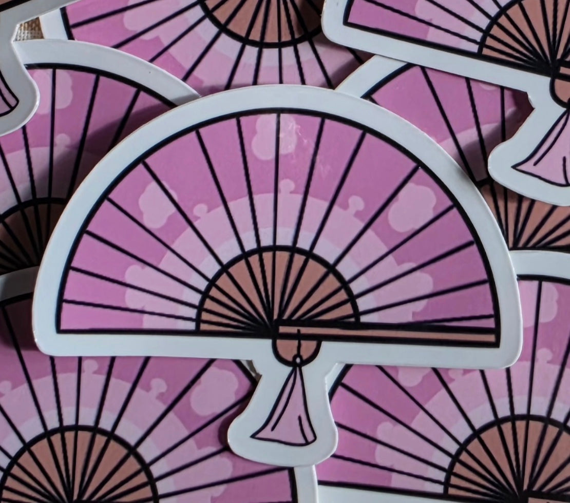 A die-cut sticker featuring a pink folding fan illustration with black outlines and a white border, shown overlapping other identical stickers.