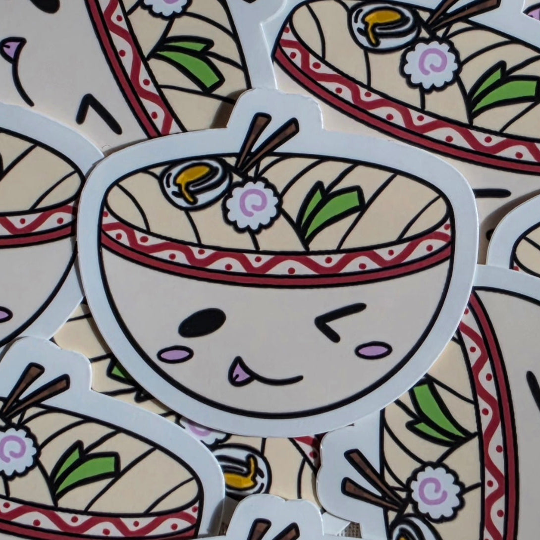 A close-up of several cartoon udon bowl stickers overlapping each other. The central sticker shows a winking face with chopsticks, noodles, and toppings in a red-bordered bowl.